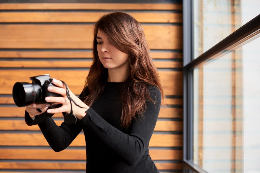 world photography day concept. woman portrait with camera in hands, photoghrapher in work