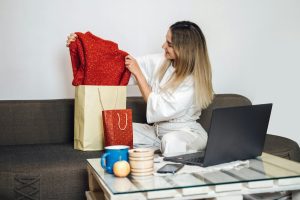 Black friday, online sale, internet shopping, ecommerce. Caucasian woman pulls new clothes out of